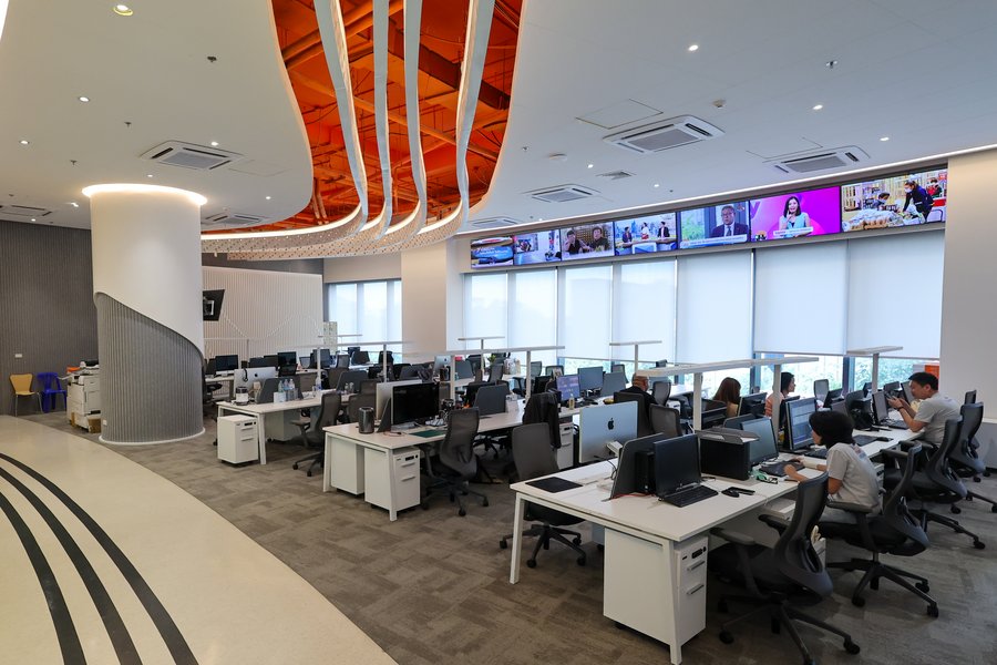 modern-newsroom-office.jpg Modern news office with active workstations and media content displays.